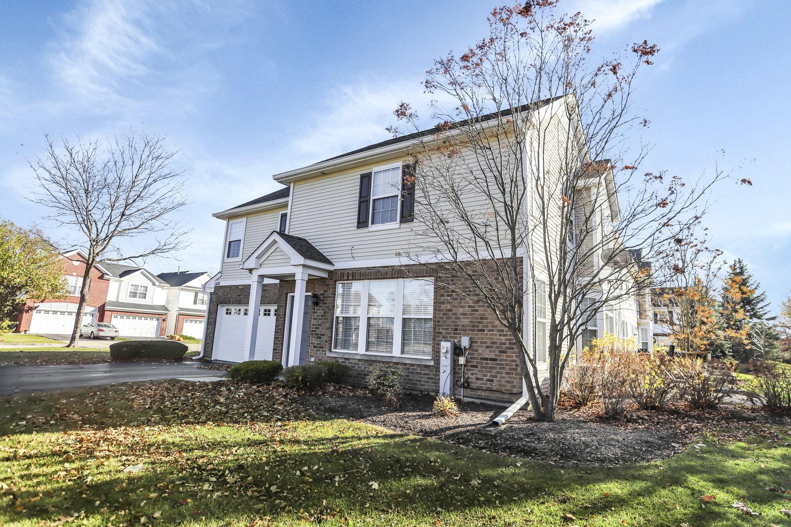 1420 Millbrook Drive Algonquin, IL 60102 - Photo 4 of 28 a view of a white house next to a yard with large trees
