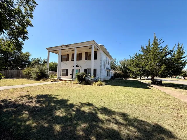a front view of a house with yard and swimming pool