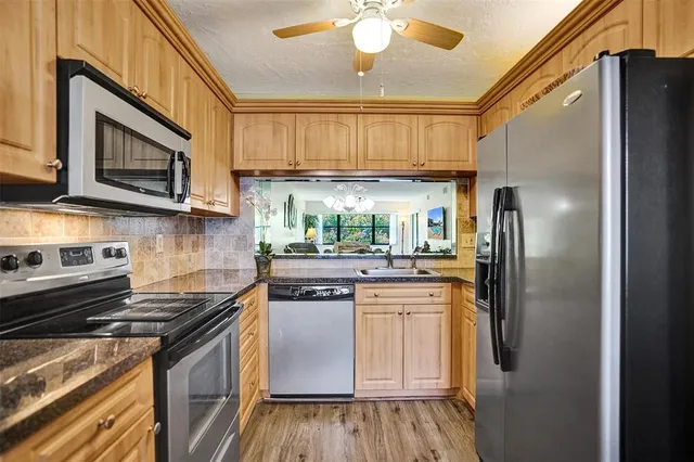 a kitchen with stainless steel appliances granite countertop a refrigerator and a stove top oven