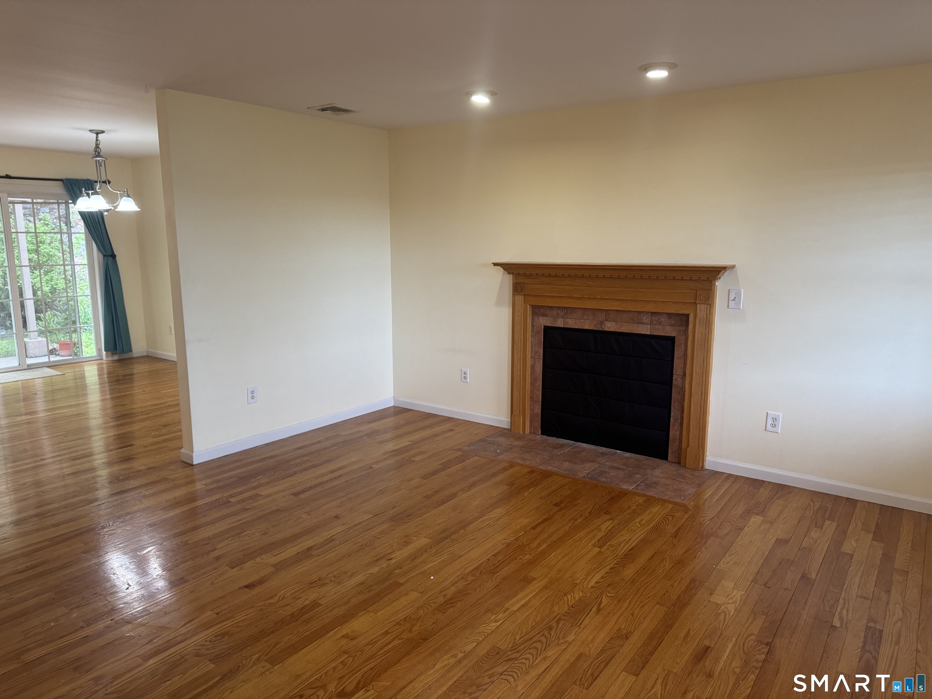 32 Tyler Hill Road Naugatuck, CT 06770 - Photo 9 of 27 a view of an empty room with wooden floor and a fireplace