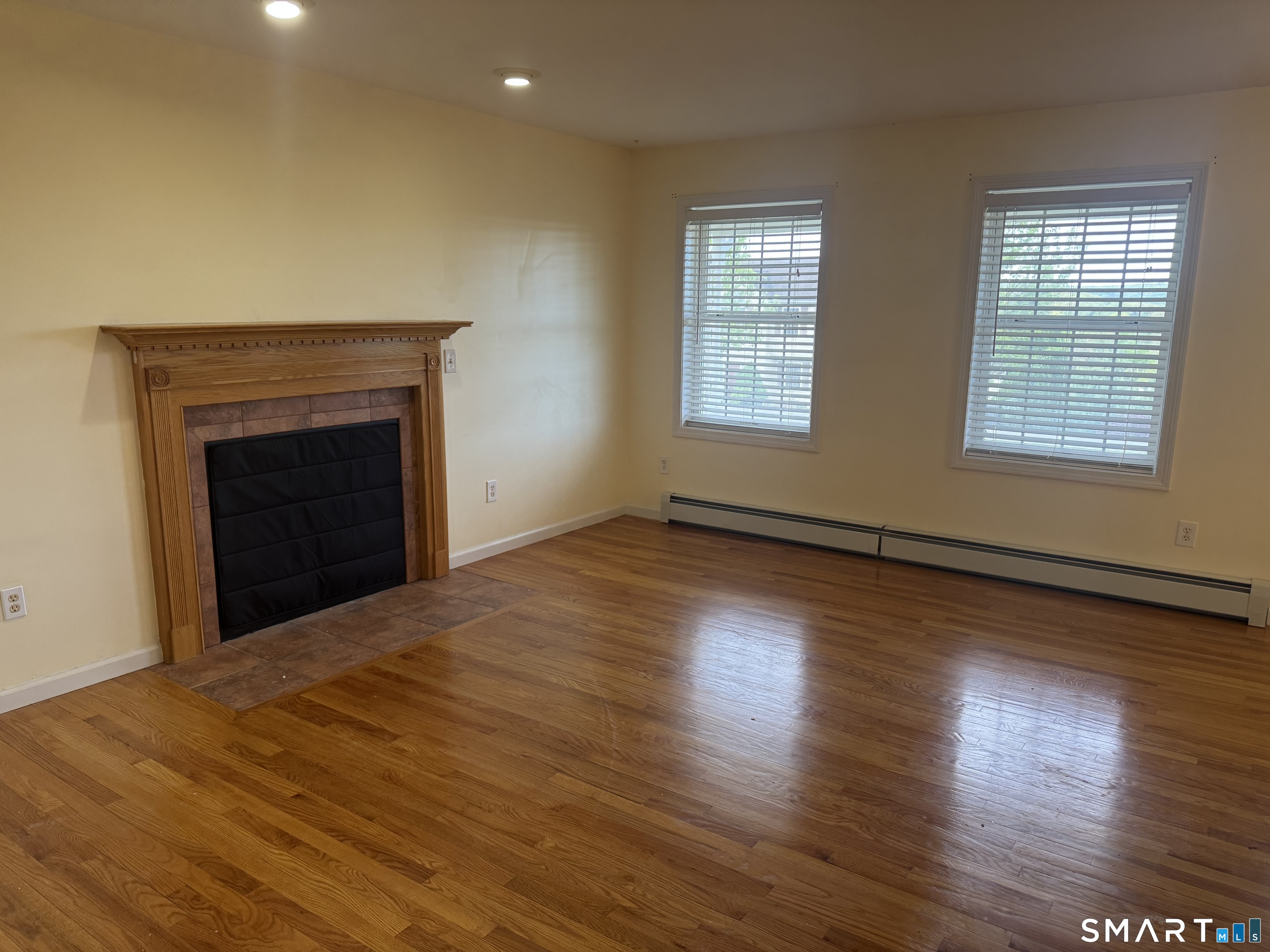 32 Tyler Hill Road Naugatuck, CT 06770 - Photo 10 of 27 wooden floor fireplace and windows in an empty room
