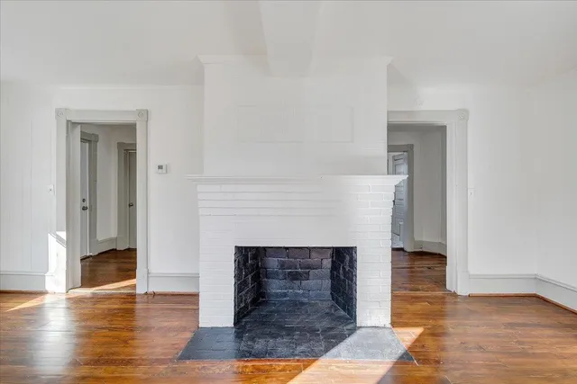 a view of a livingroom with wooden floor and a fireplace