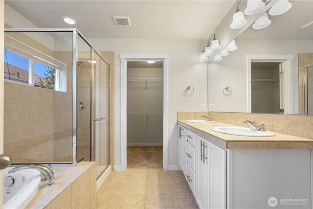 a spacious bathroom with a shower sink and mirror