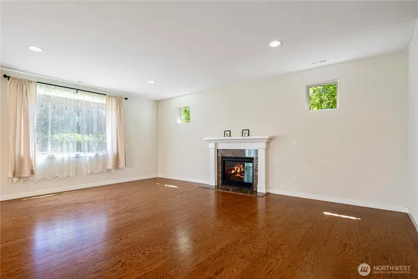 a kitchen with stainless steel appliances granite countertop a refrigerator a sink dishwasher a stove and white cabinets with wooden floor