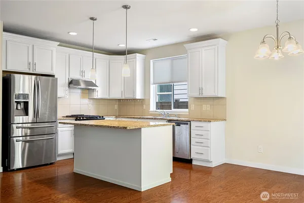 a kitchen with granite countertop a sink stove and refrigerator