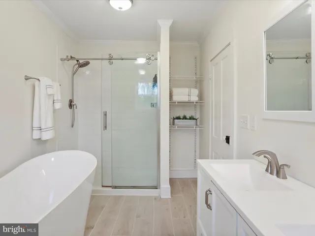 a bathroom with a tub sink shower and mirror