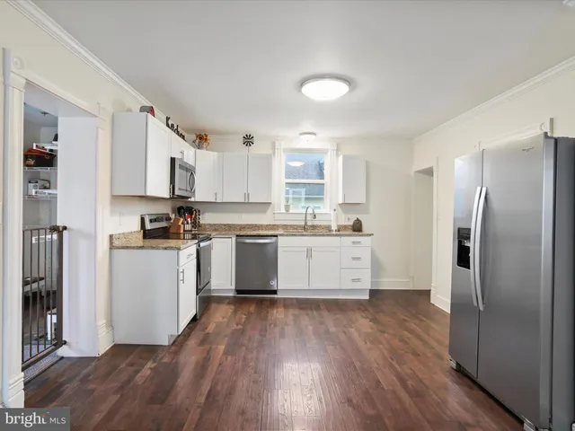 a kitchen with stainless steel appliances a refrigerator sink and cabinets