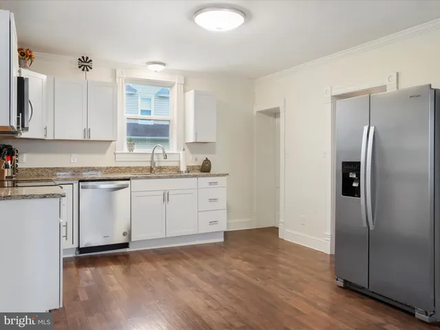 a kitchen with a refrigerator sink and cabinets