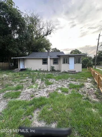 a view of a house with a yard and sitting area