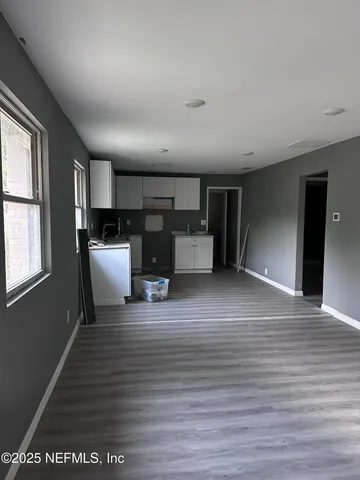 a view of a kitchen with furniture and wooden floor
