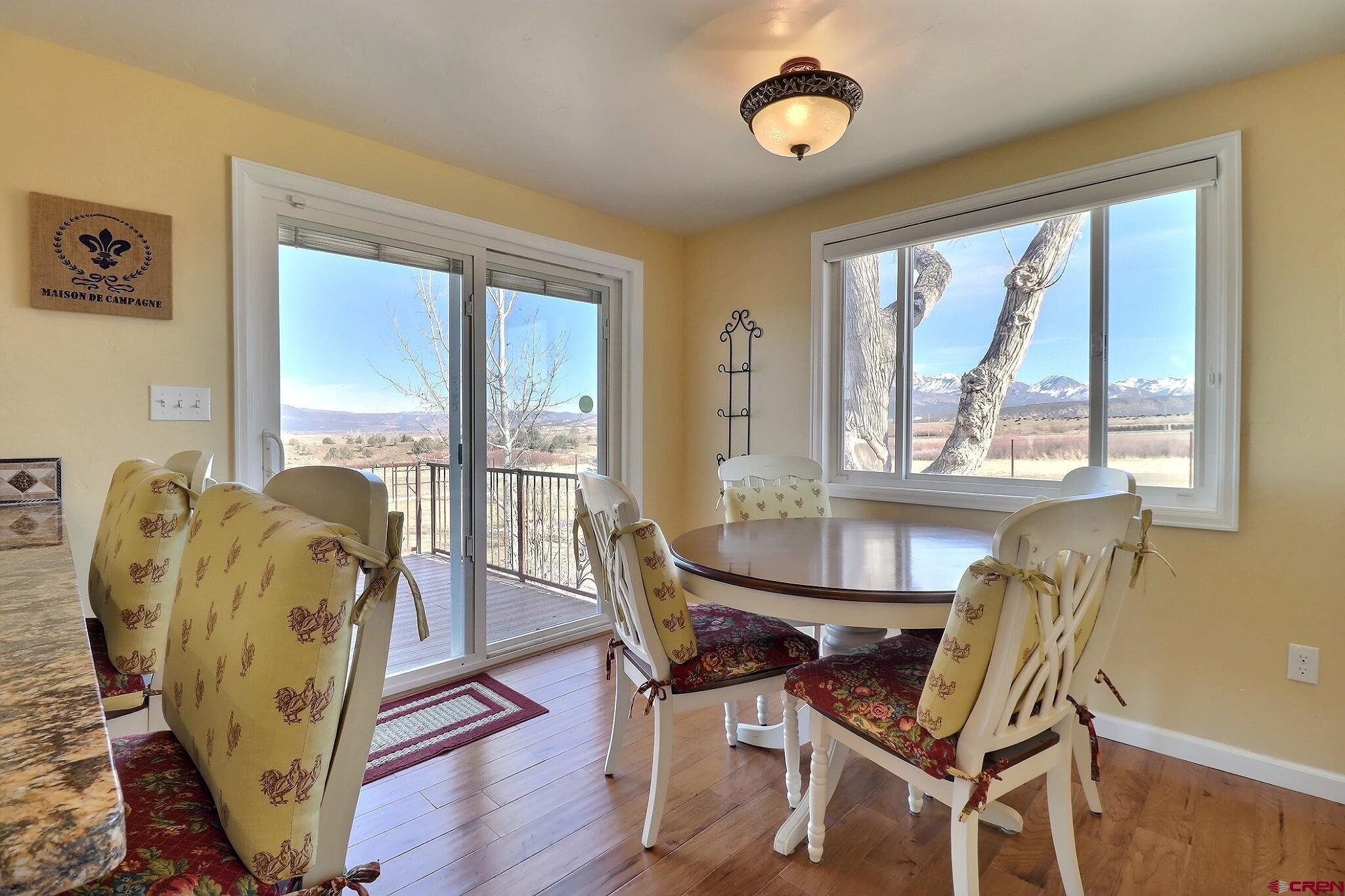 36557 Grandview Mesa Road Crawford, CO 81415 - Photo 13 of 45 a view of a dining room with furniture large windows and wooden floor