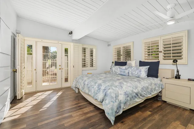 a bedroom with bed and large windows