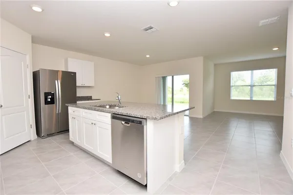 a kitchen with stainless steel appliances granite countertop a refrigerator and a sink