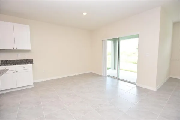 an empty room with a kitchen space and a window