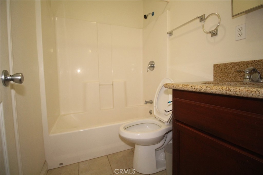 7914 Seville Avenue, Unit B Huntington Park, CA 90255 - Photo 8 of 8 a bathroom with a granite countertop sink a toilet and shower