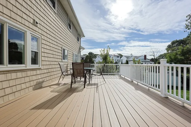 a view of a roof deck with table and chairs and wooden floor