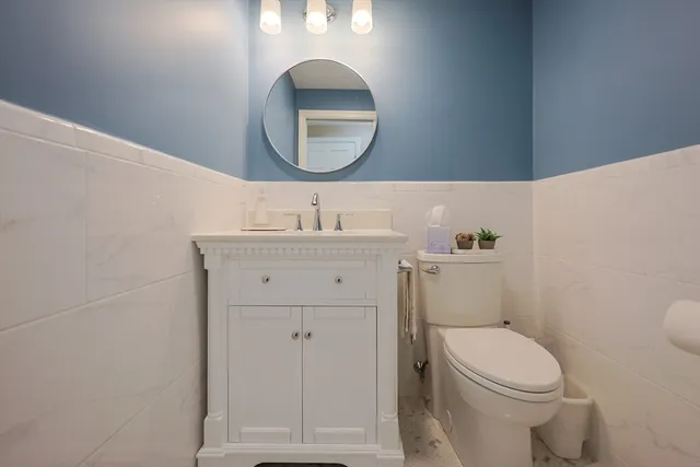 a bathroom with a toilet a sink and mirror