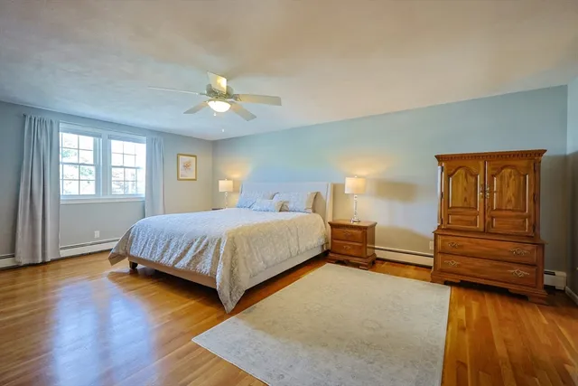 a spacious bedroom with a bed and wooden floor