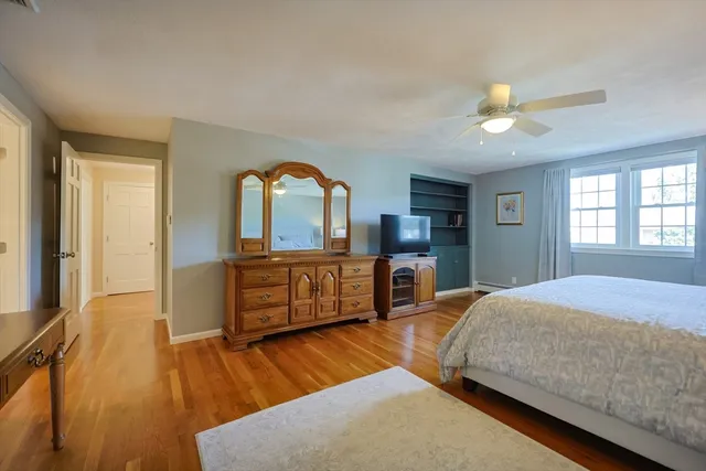 a bedroom with a bed and a dresser with mirror