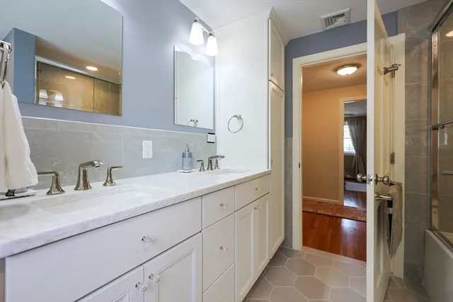 a en suite bathroom with a granite countertop sink and a mirror