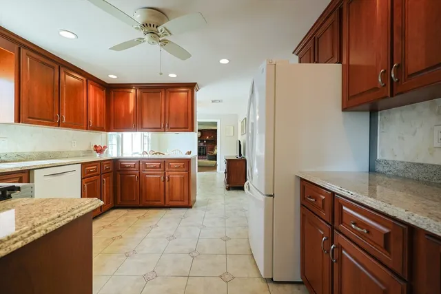 a kitchen with granite countertop a stove cabinets and refrigerator