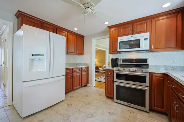 a kitchen with stainless steel appliances granite countertop a stove a refrigerator and a microwave oven