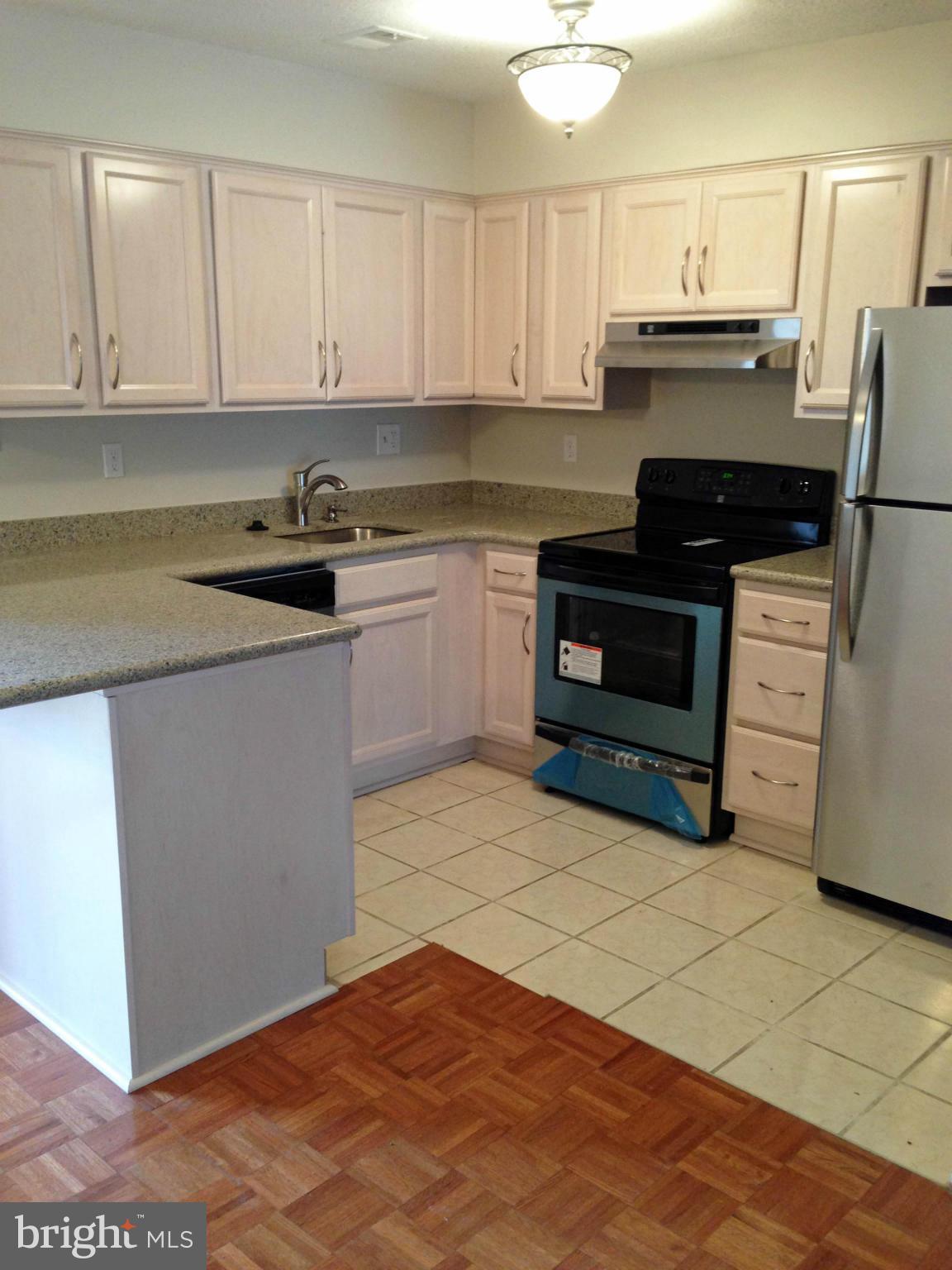 2232 White Cornus Lane Reston, VA 20191 - Photo 2 of 25 a kitchen with granite countertop a stove and cabinets