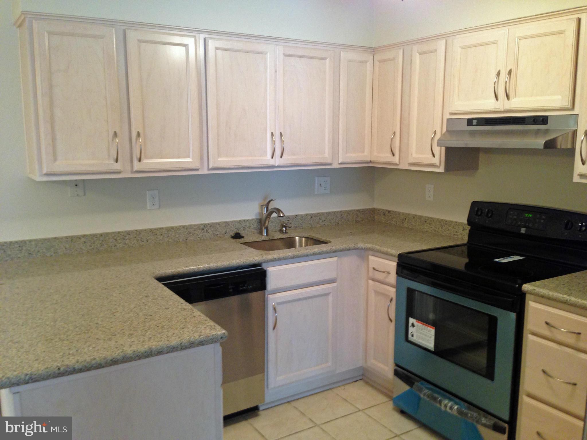 2232 White Cornus Lane Reston, VA 20191 - Photo 4 of 25 a kitchen with granite countertop white cabinets and a stove