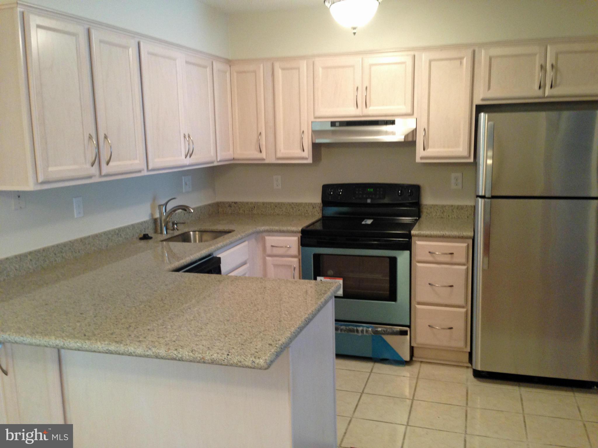2232 White Cornus Lane Reston, VA 20191 - Photo 5 of 25 a kitchen with granite countertop a refrigerator stove and cabinets