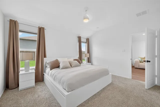 a bedroom with a bed and a large window