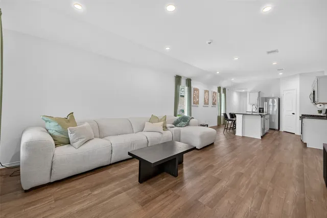 a living room with furniture and a wooden floor