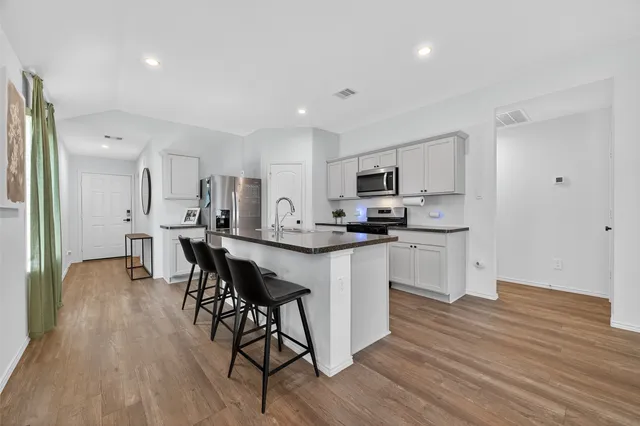 a kitchen with white cabinets and appliances