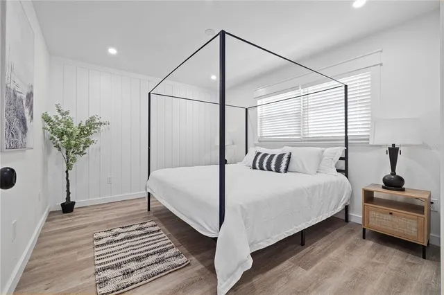 a bedroom with a bed and a potted plant