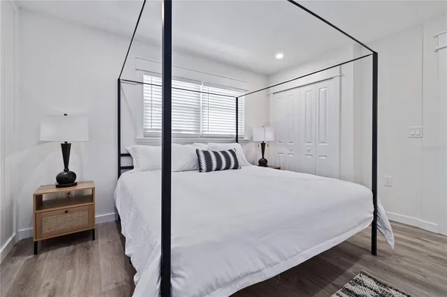 a bedroom with a bed and wooden floor