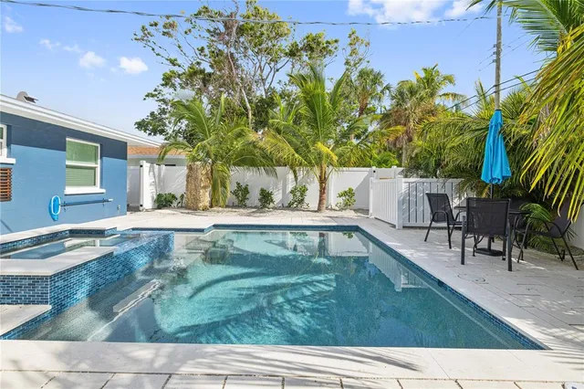a view of backyard with swimming pool and seating