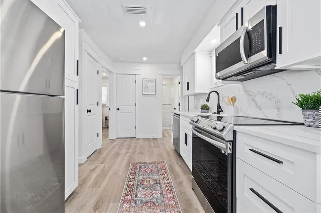 a kitchen with stainless steel appliances a stove a microwave and a refrigerator