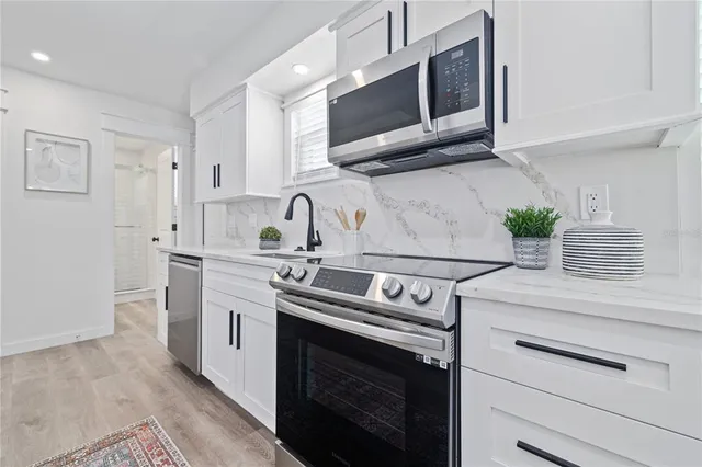 a kitchen with stainless steel appliances white cabinets and a sink