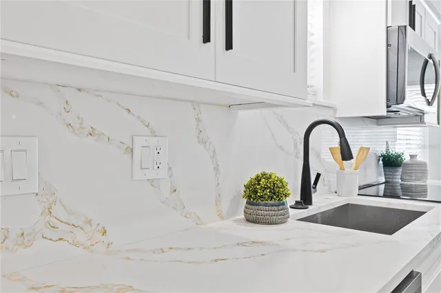 a kitchen with granite countertop a white stove and white cabinets