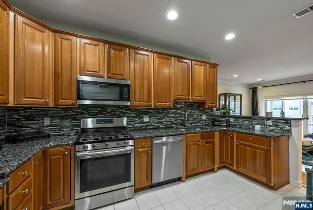 a kitchen with stainless steel appliances granite countertop sink and cabinets