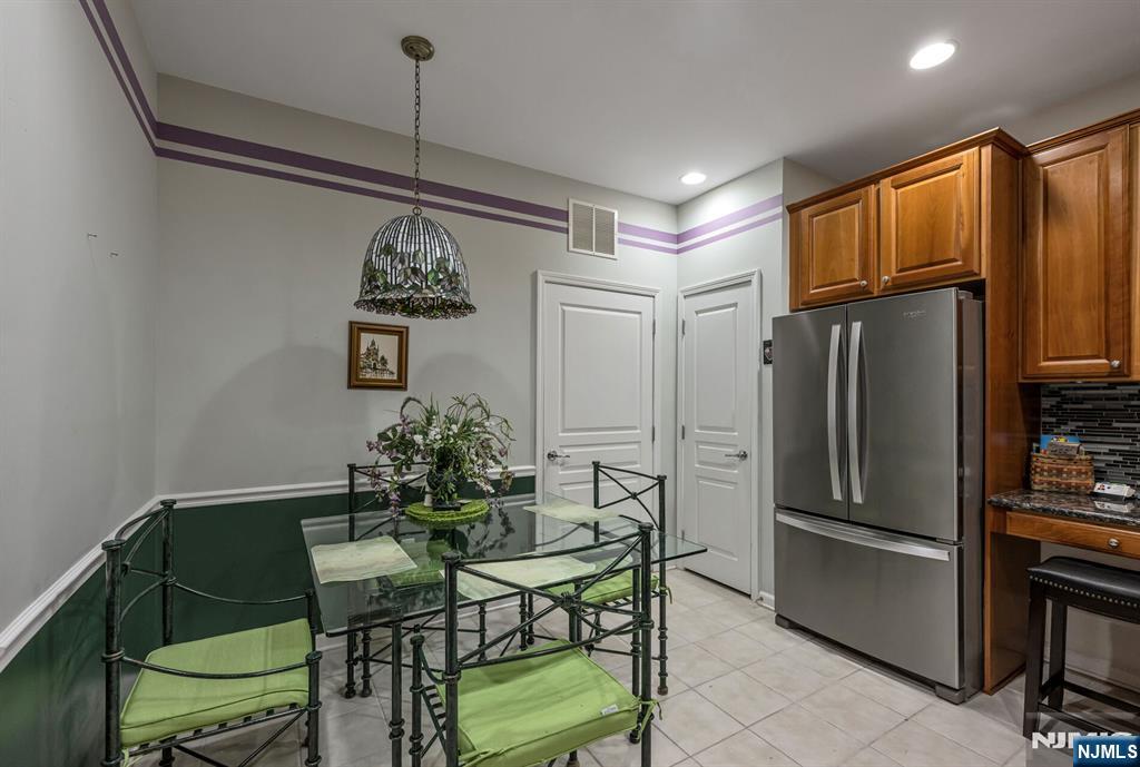 4203 Warren's Way Wanaque, NJ 07465 - Photo 14 of 35 a kitchen with stainless steel appliances granite countertop a refrigerator a stove a microwave oven a dining table and chairs with wooden floor