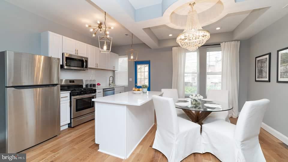 310 Marydell Road Baltimore, MD 21229 - Photo 3 of 26 a view of a dining room with furniture a kitchen island and chandelier