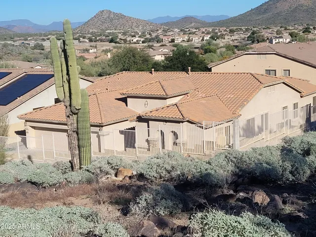 a view of a white house next to a yard