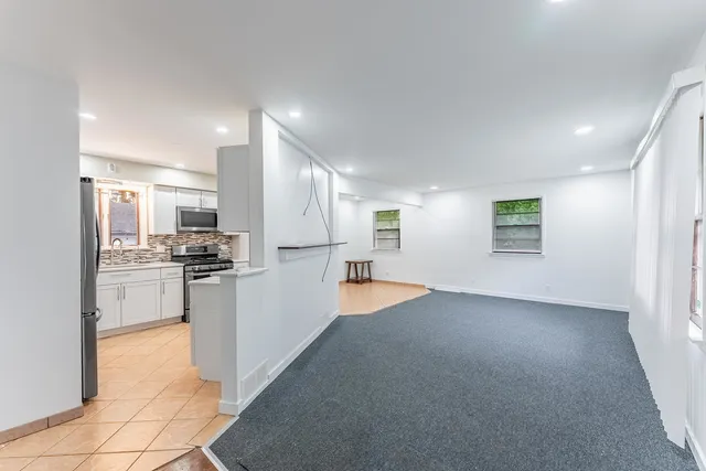 a view of a kitchen with refrigerator and white cabinets