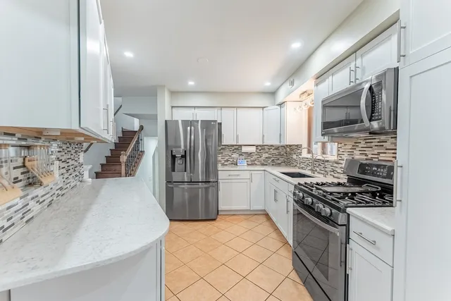a kitchen with a refrigerator sink and wooden cabinets