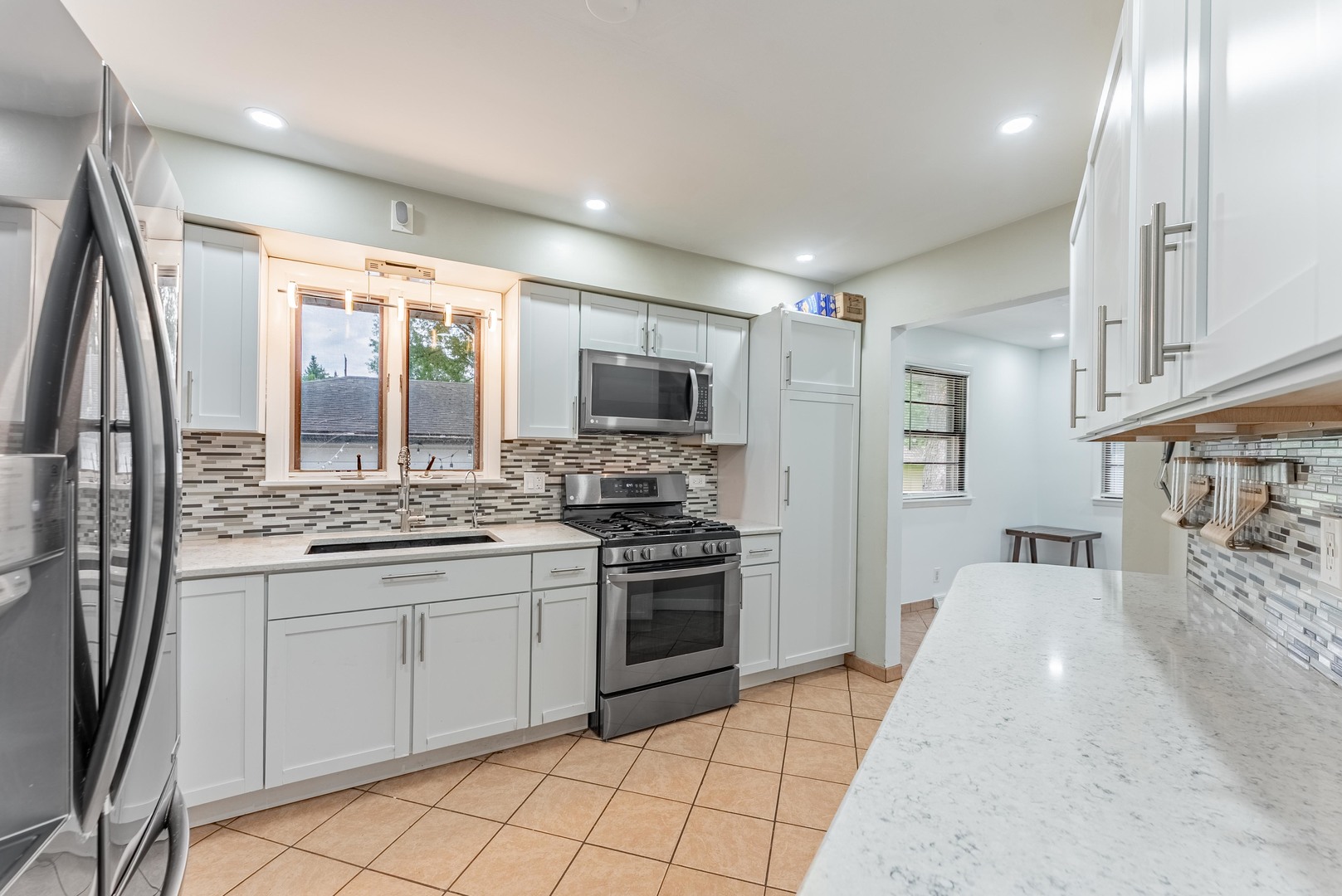 22819 Davy Court Plainfield, IL 60586 - Photo 17 of 36 a kitchen with stainless steel appliances granite countertop a stove top oven a sink a refrigerator and a granite counter tops
