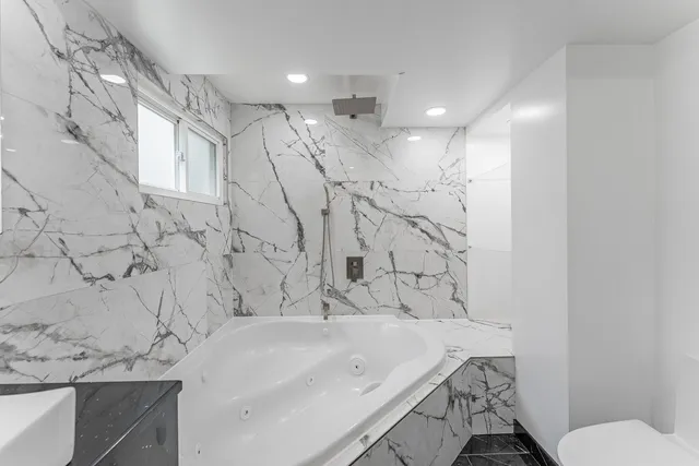 a bathroom with a sink vanity mirror and toilet
