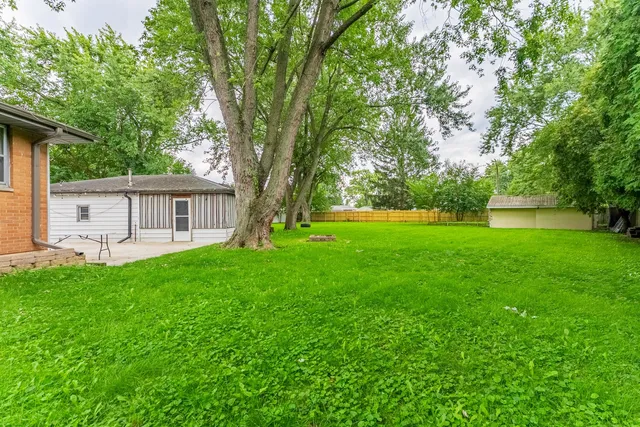a view of house with a backyard