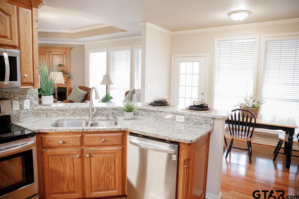 1614 Pineview Lane Hideaway, TX 75771 - Photo 11 of 48 a kitchen with stainless steel appliances granite countertop a table chairs and a wooden cabinets