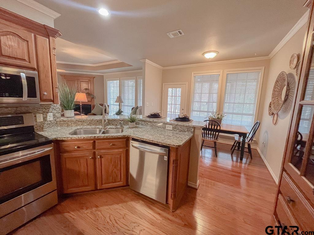 1614 Pineview Lane Hideaway, TX 75771 - Photo 44 of 48 a kitchen with granite countertop a stove a sink and wooden floors