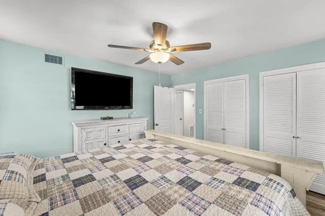 a bedroom with a bed and a flat tv screen on dresser